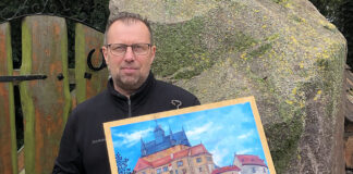 Uwe Gerschler zeigt in der Hospitalkapelle in Grimma Ölgemälde über Bauwerke aus der Region. Foto: privat